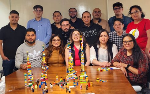 Manos adultas conectando piezas de LEGO durante una sesión facilitada por Talentoría